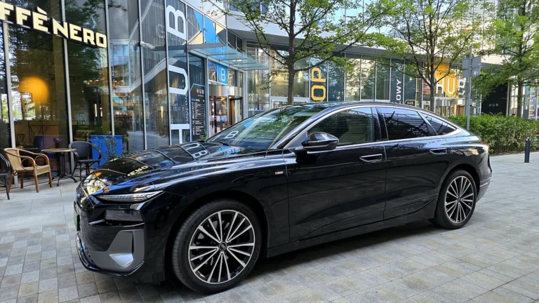 Czarne Audi A6 e-tron z kierowcą w biznesowej części Warszawy