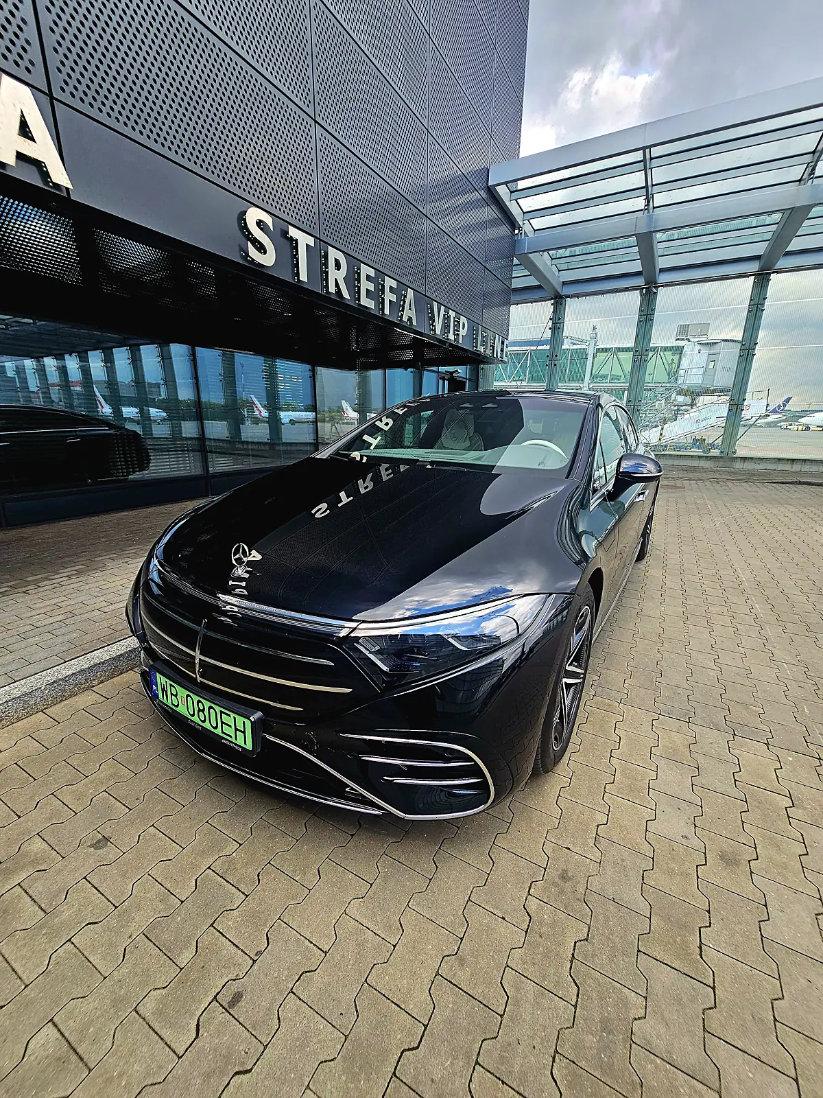 Mercedes EQS z kierowcą czeka na gościa VIP przed Strefą VIP Lotniska Chopina